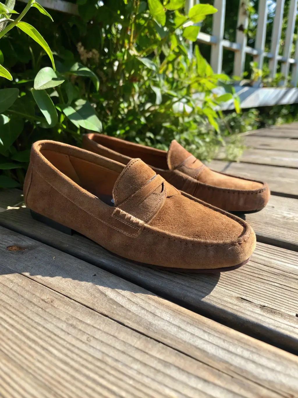 A close-up shot of a pair of handcrafted Italian leather loafers, showcasing the intricate stitching and the rich texture of the leather, placed on a polished wooden surface.